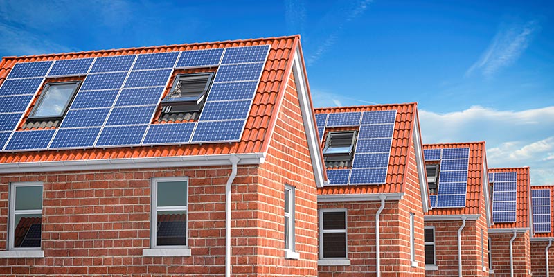 row-of-house-with-solar-panels-on-roof-on-blue-sk-2021-08-26-16-56-56-utc